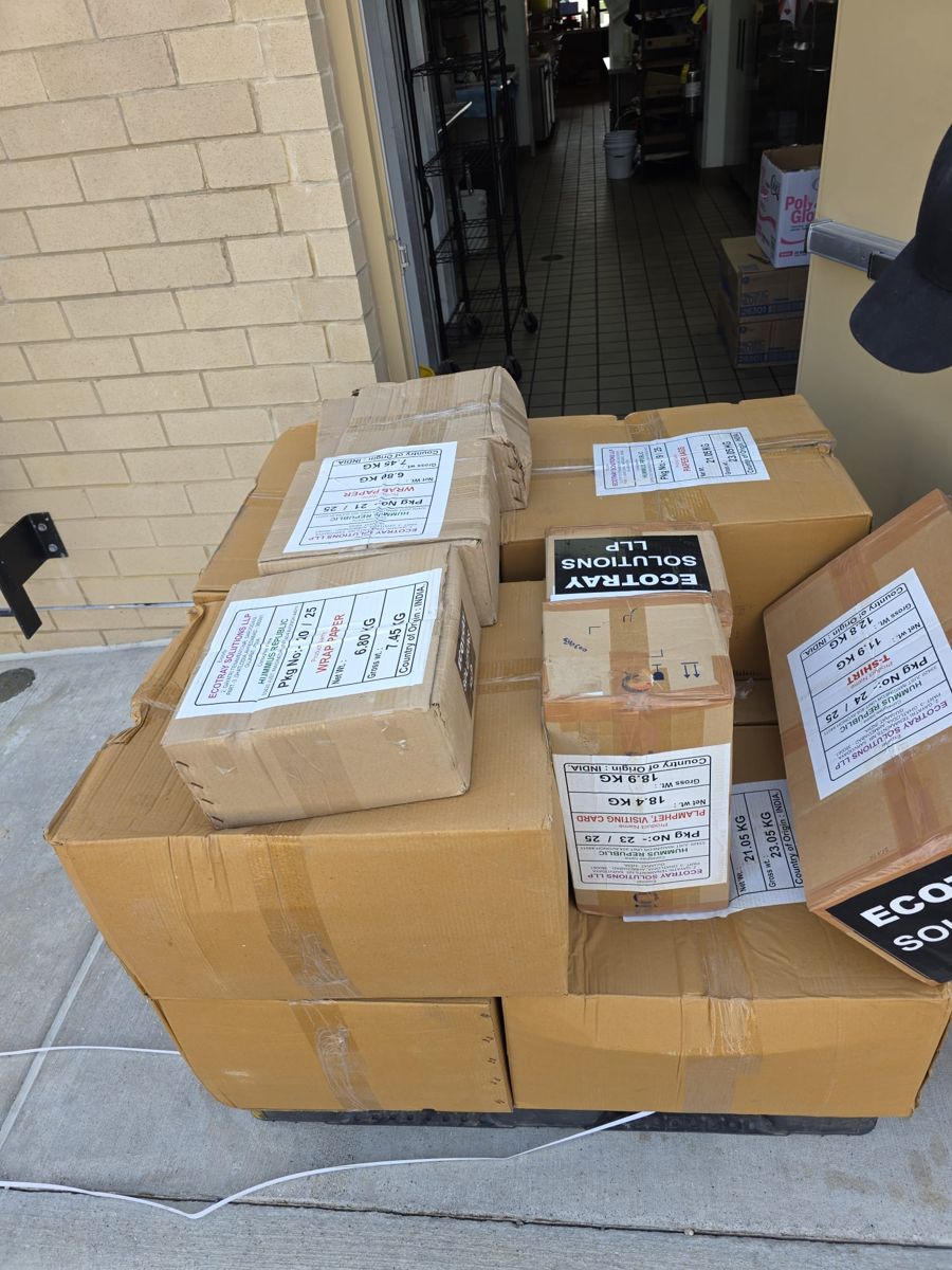 Labelled cartons of wrap paper, pamphlets, visiting cards and T-shirts